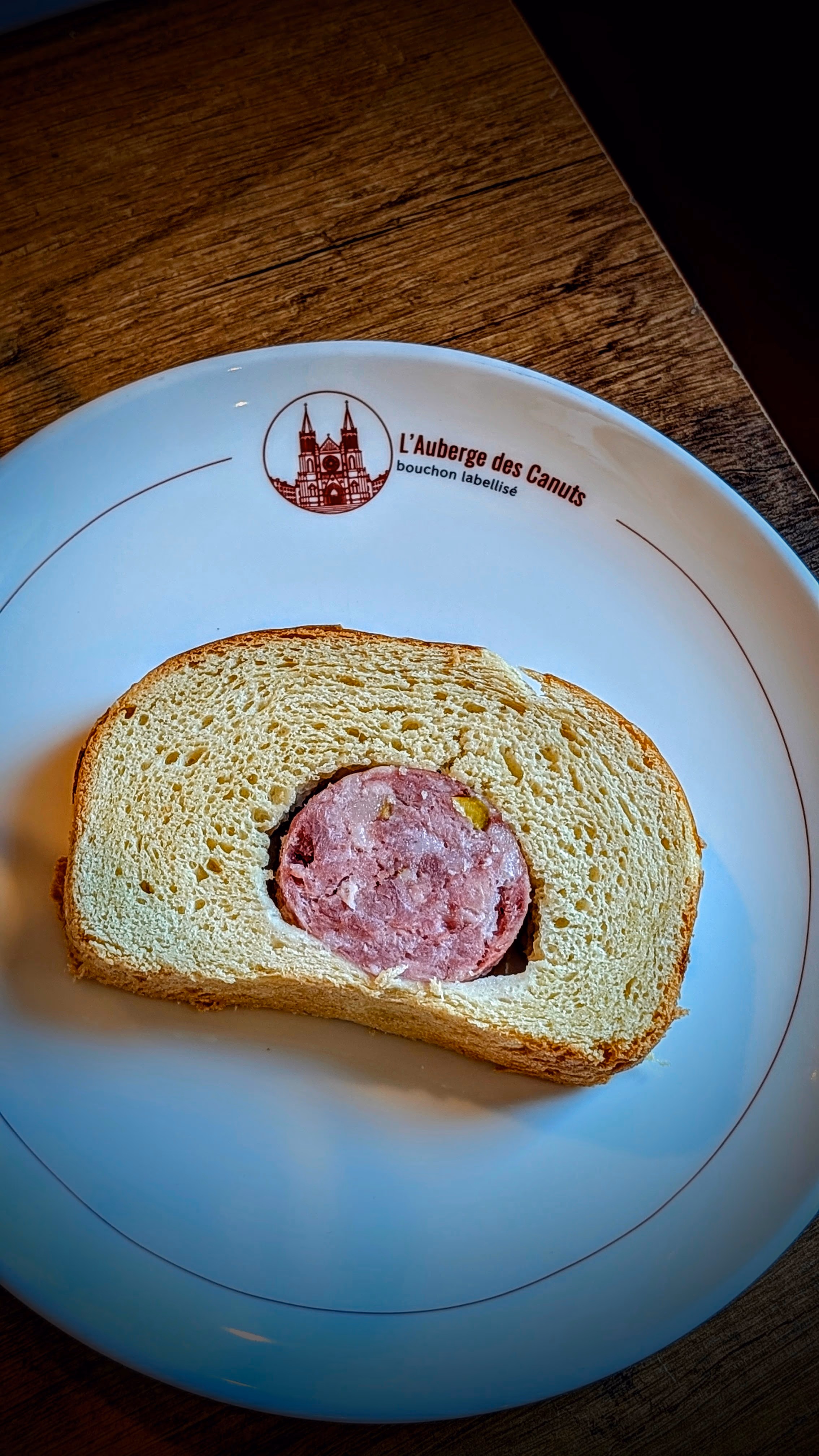 Tranche de saucisson brioché servie dans une assiette Auberge des Canuts